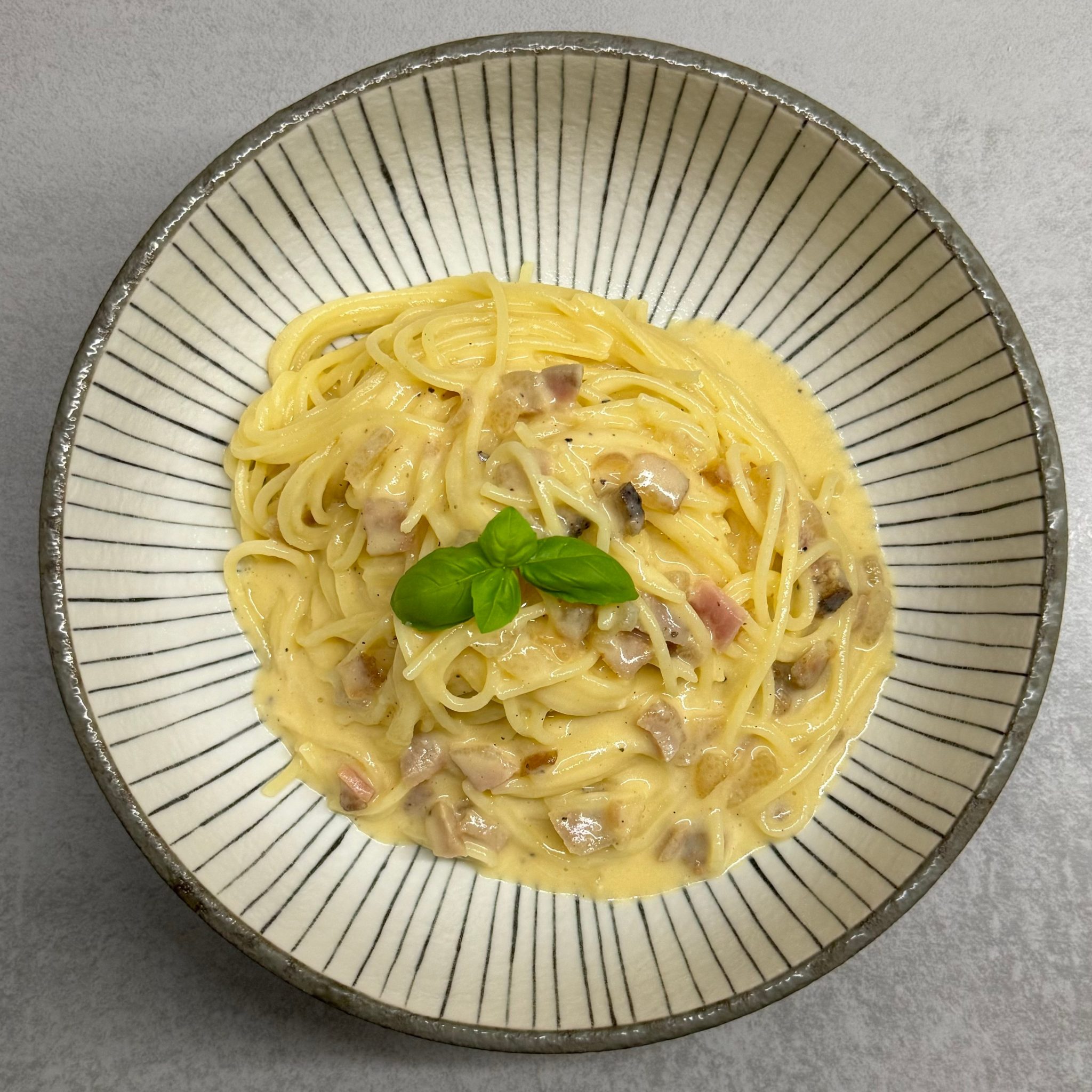 Spaghetti Carbonara mit Basilikum garniert